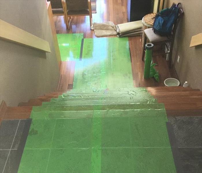green plastic covering stairs and wooden floor