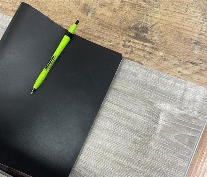 notebook with pen and paper on floor